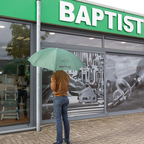 Grüner Regenschirm mit Baptistenlogo